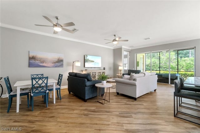 living room with ceiling fan, ornamental molding, light wood-style flooring, and baseboards
