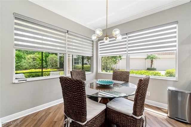 dining room with baseboards, crown molding, healthy amount of natural light, and a chandelier