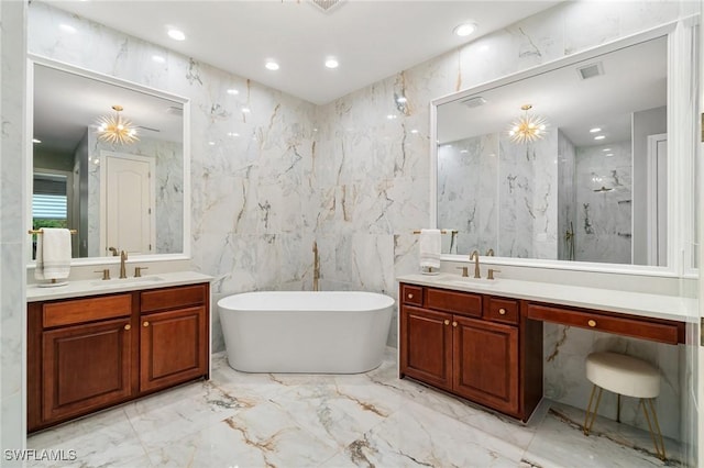full bathroom with marble tiled flooring, two vanities, tile walls, a soaking tub, and a marble finish shower