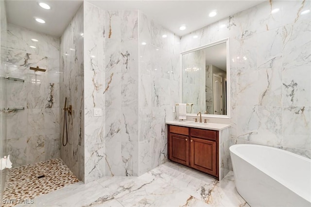 full bathroom featuring tile walls, a soaking tub, vanity, a marble finish shower, and marble tiled floors