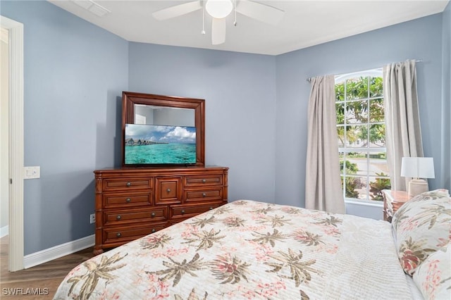 bedroom featuring wood finished floors, baseboards, and a ceiling fan