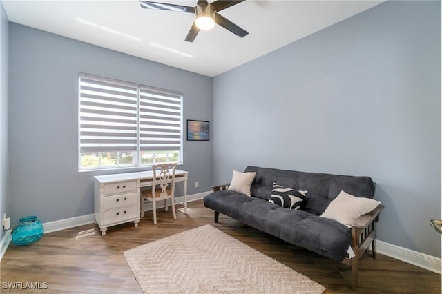sitting room featuring a ceiling fan, wood finished floors, and baseboards
