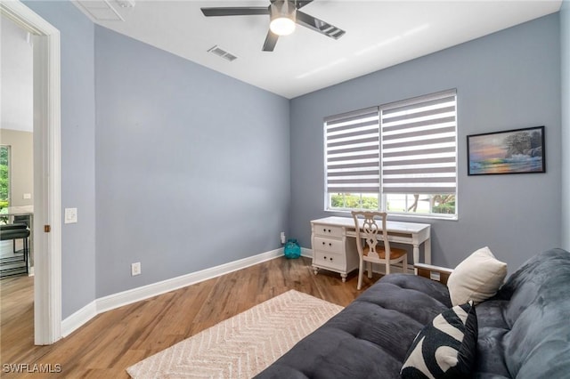 home office featuring wood finished floors, a ceiling fan, plenty of natural light, and baseboards