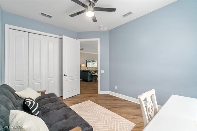 bedroom featuring wood finished floors, baseboards, a closet, and ceiling fan