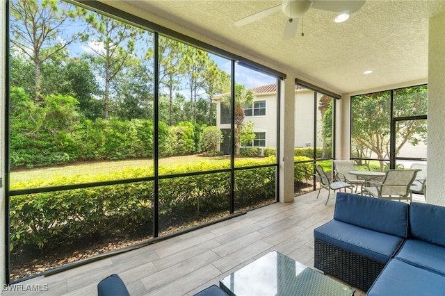 sunroom / solarium featuring a ceiling fan, an outdoor living space, and outdoor dining area