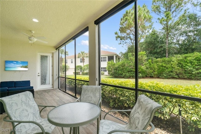 sunroom / solarium featuring a ceiling fan