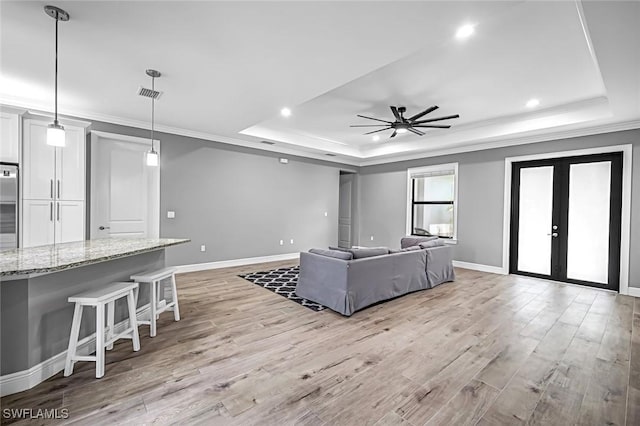 79 41st Ave NE, Naples, FL 34120 - living room featuring a tray ceiling, ornamental molding, a ceiling fan, light wood finished floors, and recessed lighting