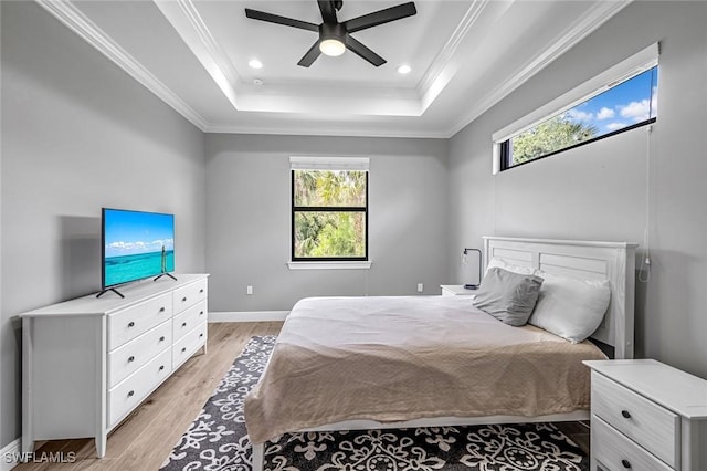 79 41st Ave NE, Naples, FL 34120 - bedroom with a tray ceiling, multiple windows, light wood-style flooring, ornamental molding, and a ceiling fan