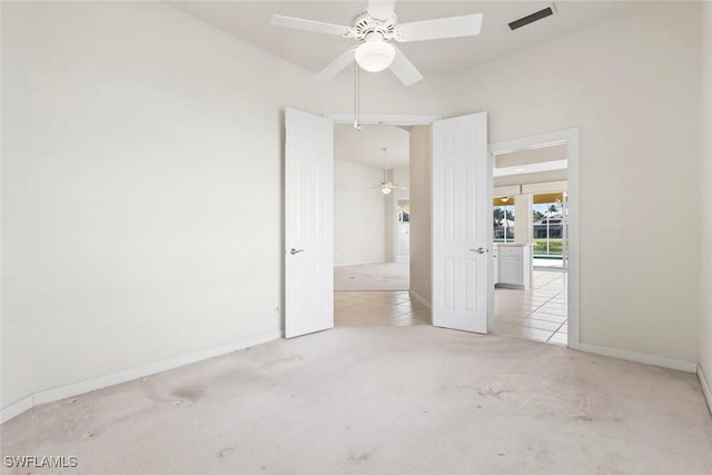 carpeted empty room with a ceiling fan and baseboards