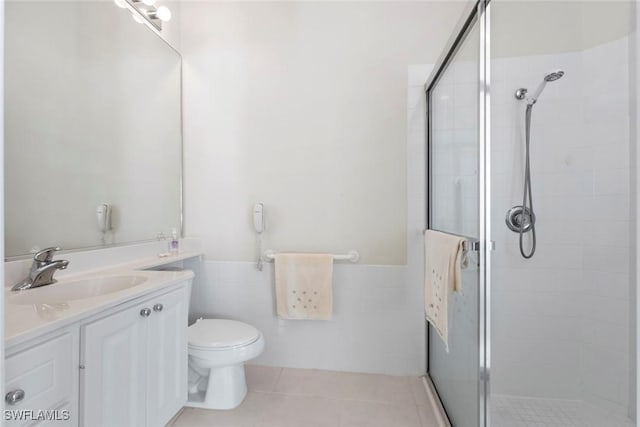 full bath with a shower stall, vanity, toilet, wainscoting, and tile patterned flooring