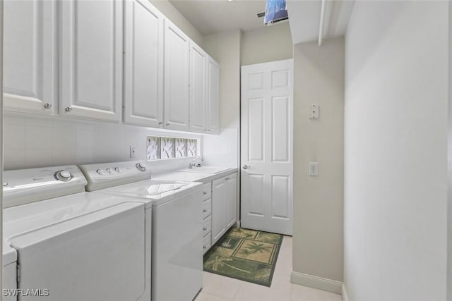 laundry room with cabinet space, independent washer and dryer, and baseboards