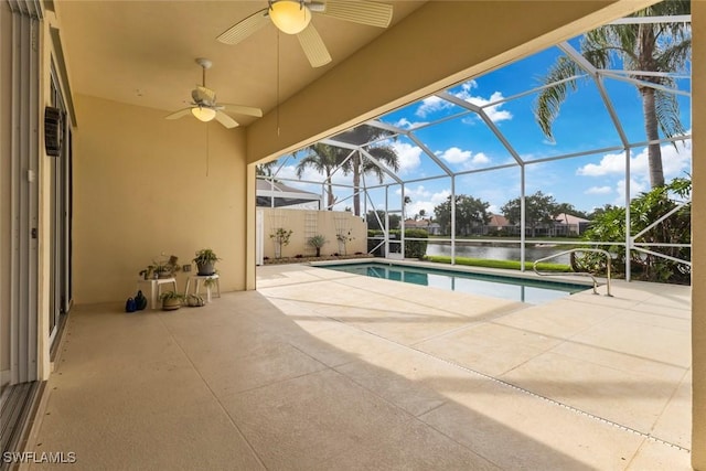 swimming pool with a patio area, a ceiling fan, a lanai, and a water view
