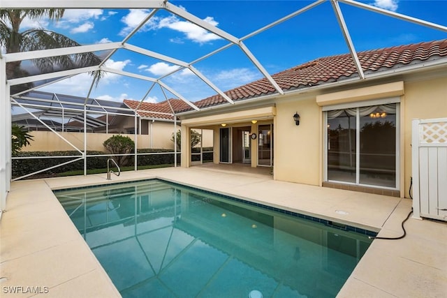 view of swimming pool with a patio area and a lanai