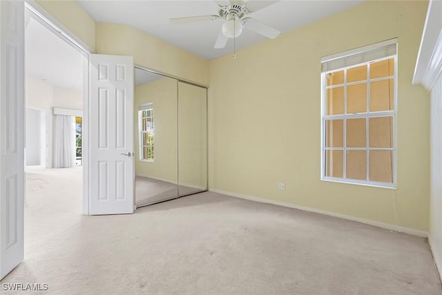 unfurnished bedroom with carpet floors, a closet, baseboards, and a ceiling fan