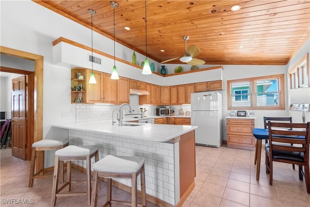 150 Pearl St, Fort Myers Beach, FL 33931 - kitchen with freestanding refrigerator, wood ceiling, stainless steel microwave, a peninsula, and light countertops