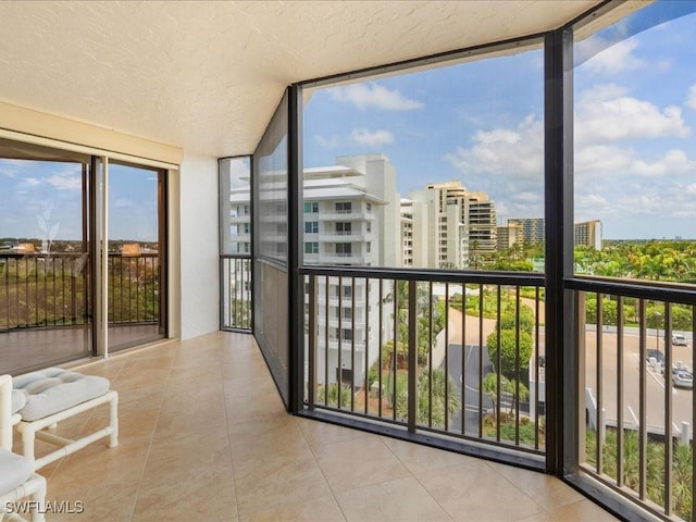840 S Collier Blvd Unit 706, Marco Island, FL 34145 - unfurnished sunroom featuring expansive windows, tile patterned flooring, a city view, and a textured ceiling