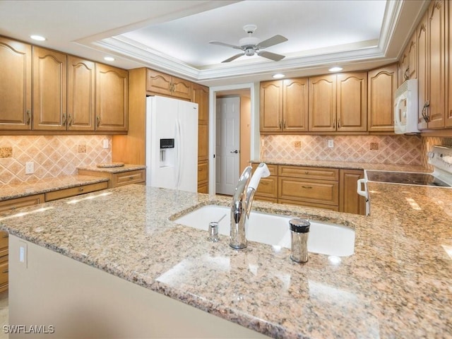 840 S Collier Blvd Unit 706, Marco Island, FL 34145 - kitchen with white appliances, light stone counters, a raised ceiling, a ceiling fan, and decorative backsplash