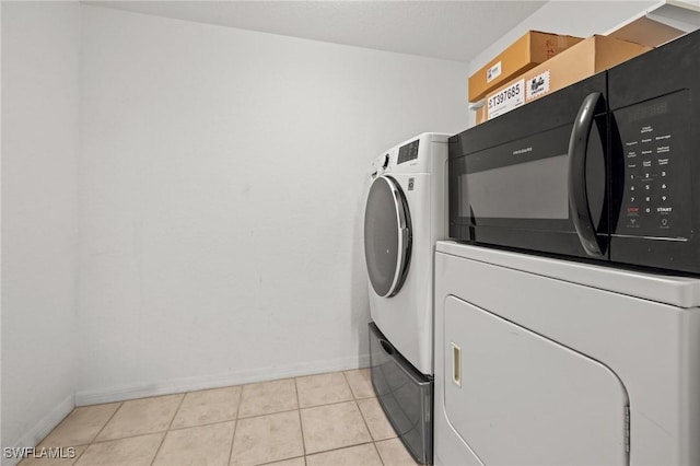 27075 Matheson Ave Unit 105, Bonita Springs, FL 34135 - clothes washing area featuring washing machine and dryer, baseboards, and light tile patterned flooring