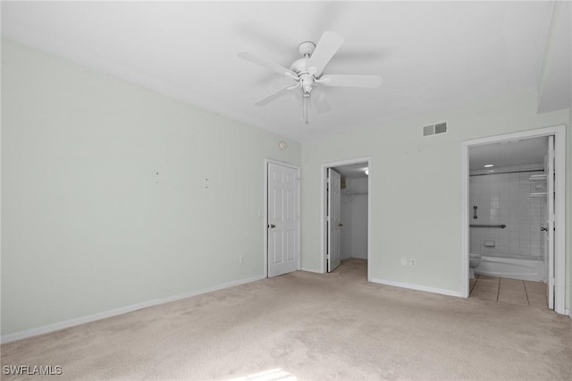 27075 Matheson Ave Unit 105, Bonita Springs, FL 34135 - unfurnished bedroom featuring light colored carpet, baseboards, a walk in closet, a closet, and connected bathroom