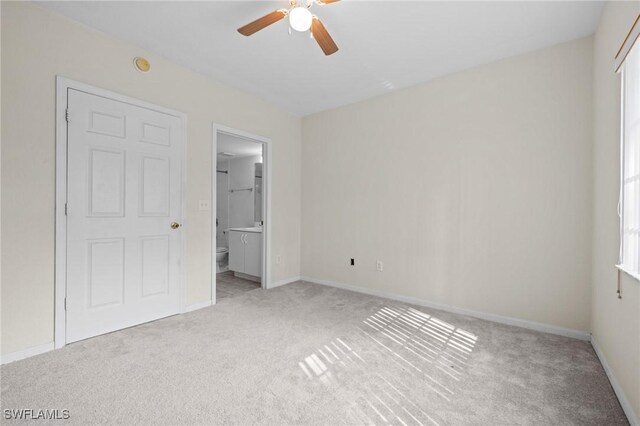 27075 Matheson Ave Unit 105, Bonita Springs, FL 34135 - unfurnished bedroom with light carpet, ensuite bathroom, baseboards, and a ceiling fan