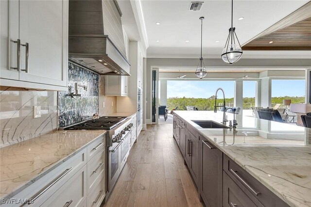26906 Mclaughlin Blvd, Bonita Springs, FL 34134 - kitchen with custom exhaust hood, double oven range, light wood finished floors, white cabinetry, and recessed lighting