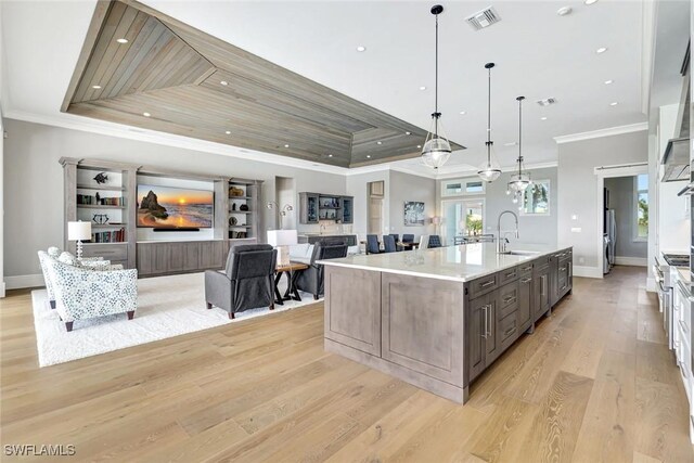 26906 Mclaughlin Blvd, Bonita Springs, FL 34134 - kitchen with a sink, ornamental molding, healthy amount of natural light, light wood finished floors, and a large island with sink
