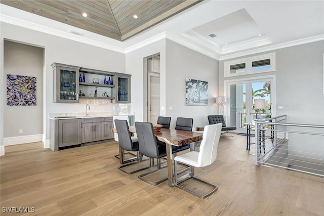 26906 Mclaughlin Blvd, Bonita Springs, FL 34134 - dining area featuring wet bar, a tray ceiling, light wood-type flooring, french doors, and recessed lighting
