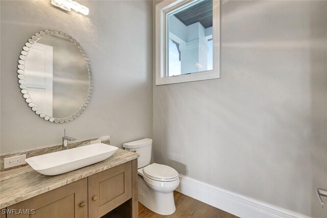 26906 Mclaughlin Blvd, Bonita Springs, FL 34134 - half bathroom featuring toilet, wood finished floors, and vanity