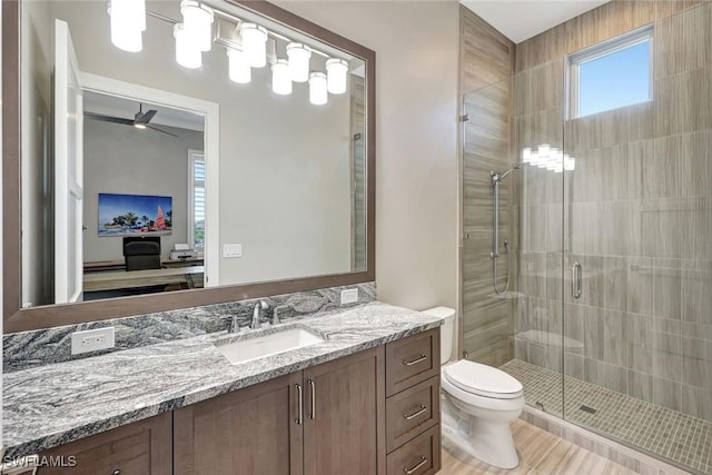 26906 Mclaughlin Blvd, Bonita Springs, FL 34134 - bathroom featuring a stall shower, toilet, vanity, and a ceiling fan