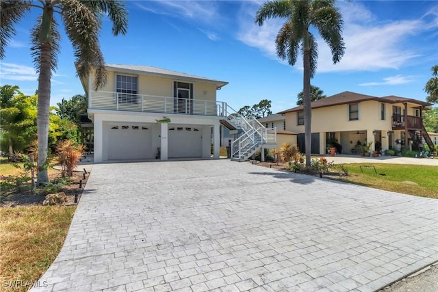 4471 Mariner Rd, Bonita Springs, FL 34134 - coastal home with decorative driveway, stairway, a garage, and stucco siding