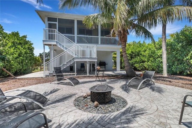 4471 Mariner Rd, Bonita Springs, FL 34134 - rear view of house with a fire pit, a patio, a sunroom, stairs, and stucco siding