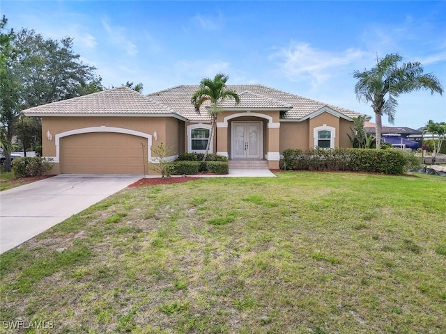 mediterranean / spanish home featuring stucco siding, an attached garage, a front yard, a tiled roof, and concrete driveway