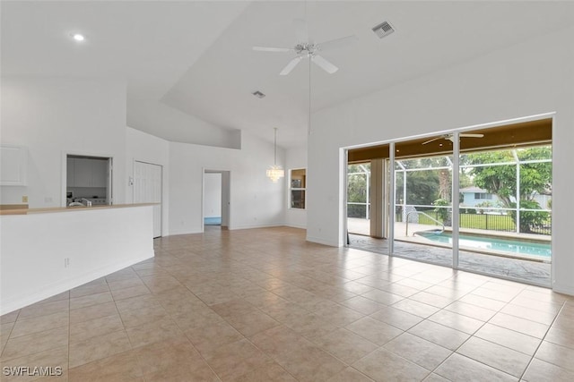 unfurnished living room featuring high vaulted ceiling, a ceiling fan, tile patterned flooring, and baseboards