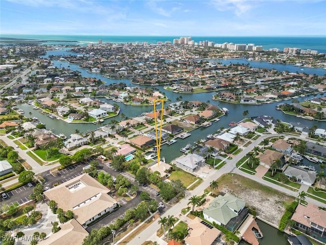 aerial view of property and surrounding area featuring a nearby body of water and nearby suburban area