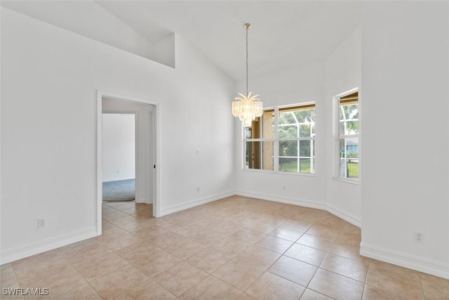 unfurnished dining area with a chandelier, tile patterned flooring, baseboards, and high vaulted ceiling