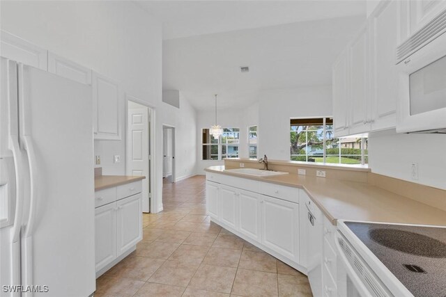kitchen featuring white appliances, a sink, light tile patterned flooring, white cabinets, and a peninsula