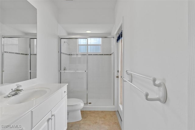 full bathroom with a stall shower, vanity, tile patterned flooring, and toilet