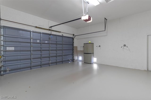 garage with freestanding refrigerator and a garage door opener