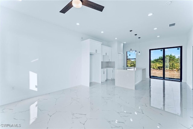 unfurnished living room featuring recessed lighting, light marble finish flooring, and ceiling fan