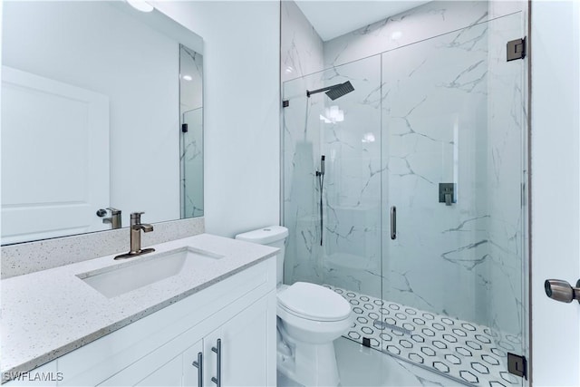 bathroom featuring a marble finish shower, toilet, and vanity