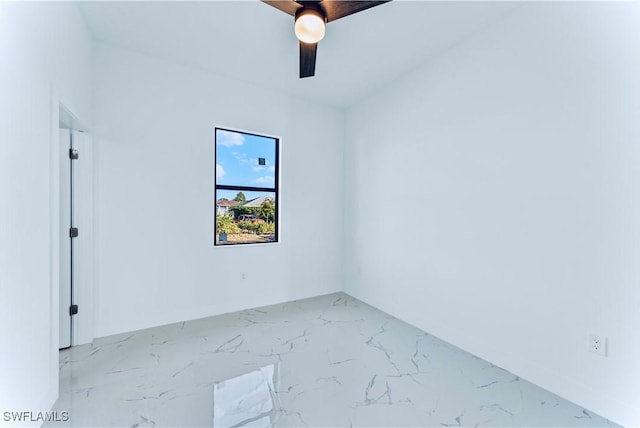 unfurnished room with marble finish floors and a ceiling fan