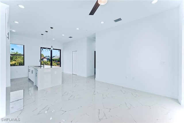 unfurnished room with recessed lighting, a ceiling fan, a sink, and light marble finish flooring