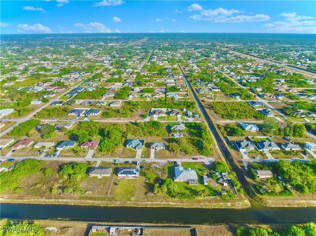 aerial view of property's location featuring a nearby body of water and nearby suburban area