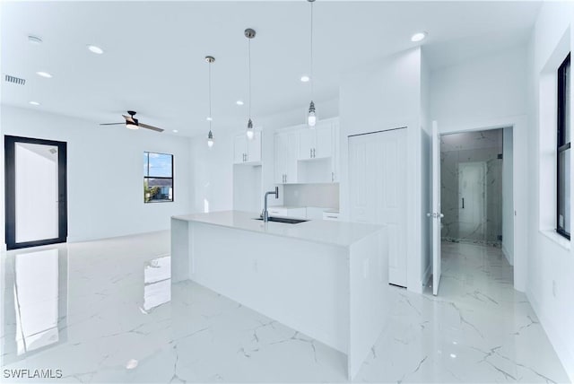 kitchen featuring a sink, light marble finish flooring, white cabinets, ceiling fan, and recessed lighting