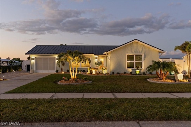ranch-style home with driveway, an attached garage, stucco siding, and a front lawn