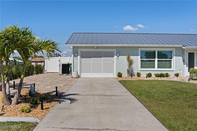 view of front facade with stucco siding, driveway, a garage, and a standing seam roof