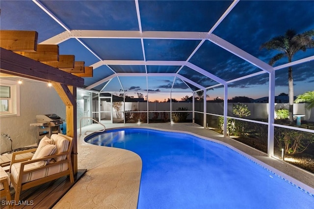 pool at dusk with a patio area and a lanai