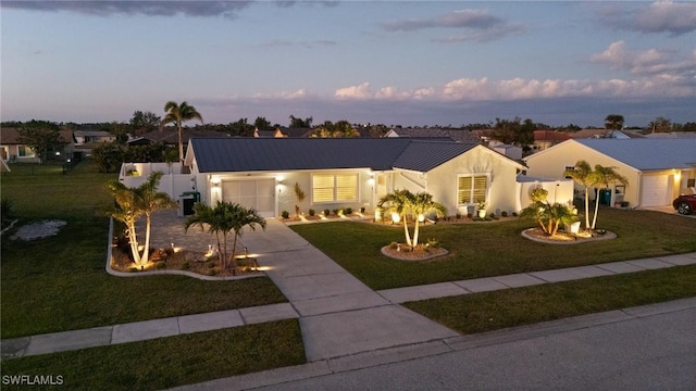 view of front facade featuring concrete driveway, a garage, stucco siding, and metal roof