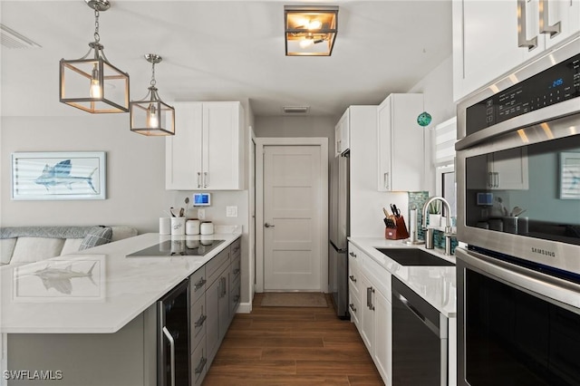 kitchen with a sink, stainless steel appliances, wine cooler, a peninsula, and dark wood-style floors