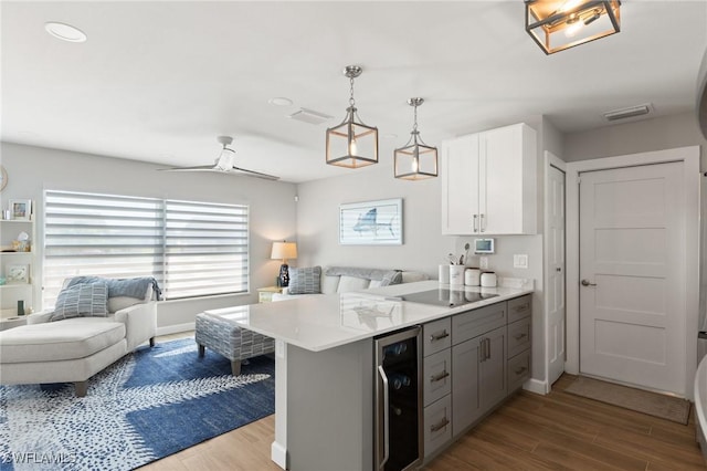 kitchen with open floor plan, beverage cooler, black electric cooktop, and a peninsula